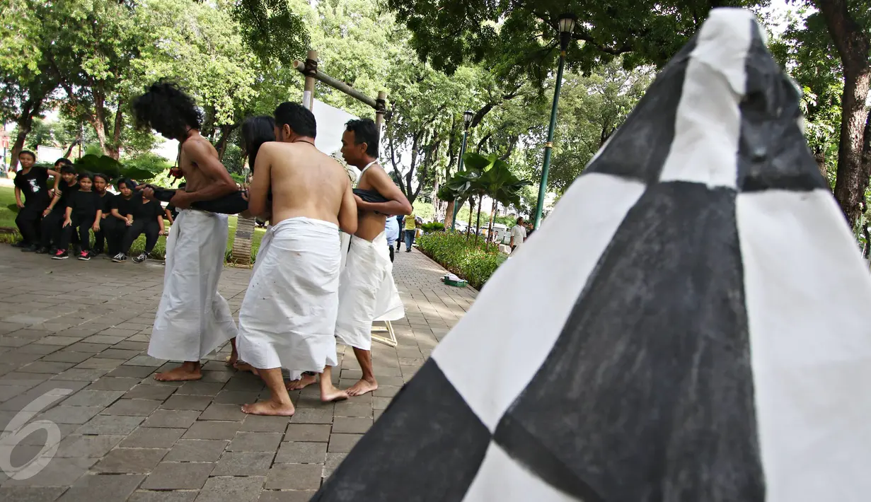 Kelompok Sajinah Seniman Solo melakukan adegan pada pertunjukan berjudul 'Menuju Putih' di Taman Suropati, Jakarta, Rabu (23/12). Pertunjukan itu merupakan bentuk ekspresi seniman dalam mewujudkan cita-cita Indonesia (Liputan6.com/Immanuel Antonius)
