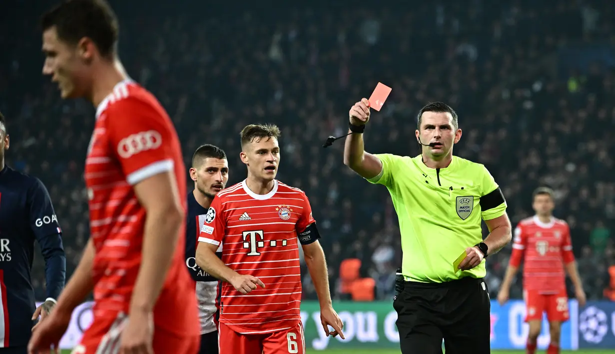 Bek Bayern Muenchen, Benjamin Pavard (Kiri) ditunjukkan kartu merah oleh wasit Inggris Michael Oliver saat bertanding melawan PSG selama pertandingan leg pertama babak 16 besar Liga Champions di stadion Parc des Princes di Paris, Rabu (15/2/2023). Bayern menang tipis atas PSG dengan skor 1-0. (AFP/Anne-Christine Poujoulat)