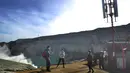 Wisatawan asal Malaysia bermain gawai dekat menara BTS di Puncak Kawah ijen, Banyuwangi, Selasa (3/7). Pemasangan menara BTS tersebut dilakukan dalam rangka mendukung target kunjungan turis asing sebesar 17 juta pada tahun 2018. (Merdeka.com/Arie Basuki)