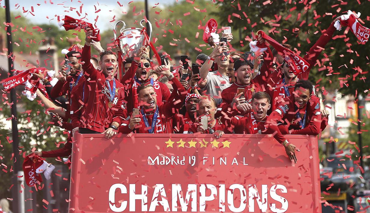 Para pemain Liverpool menyapa fans saat parade juara Liga Champions 2019 di Liverpool, Minggu (2/6). Ribuan fans tumpah ruah di jalanan untuk merayakan keberhasilan pemain membawa pulang trofi Si Kuping Besar ke kota Liverpool. (AP/Barrington Coombs)