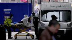 Seorang pasien didorong menggunakan troli di luar Rumah Sakit Royal London, Inggris, 6 Januari 2022. Inggris memangkas waktu isolasi pasien COVID-19 dari 10 menjadi 7 hari karena kekurangan tenaga kesehatan akibat lonjakan kasus yang dipicu Omicron. (AP Photo/Matt Dunham)