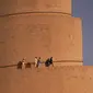 Warga Irak berjalan di menara spiral Malwiya, monumen nasional Irak yang berharga pada pertengahan abad kesembilan, di dalam Kota Arkeologi Samarra, di Samarra, utara Baghdad (26/7/2022). Menara helikoid 50m dari batu bata yang dikeringkan dan dipanggang dengan sinar matahari, mencontoh ziggurat kuno yang dibangun untuk melambangkan kekuatan Islam selama kekhalifahan Abbasiyah, terdaftar sebagai Situs Warisan Dunia UNESCO pada tahun 2007. (AFP/Ismael Adnan)