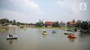 Wisatawan menaiki perahu saat mengunjungi TMII, Jakarta, Kamis (20/8/2020). Libur panjang yang bertepatan tahun baru islam di manfaatkan masyarakat bersama keluarga  berlibur ke sejumlah tempat wisata. (Liputan6.com/Faizal Fanani)