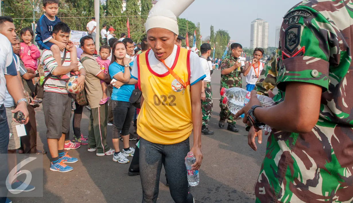 Seorang peserta terlihat letih saat mengikuti lomba lari 10K di Silang Monas, Jakarta, Minggu (26/9/2015). Lomba lari tersebut dibuka oleh Panglima TNI Jenderal TNI Gatot Nurmantyo dan digelar untuk memperingati Hut TNI ke 70. (Liputan6.com/Faizal Fanani)