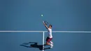Petenis Swiss, Roger Federer, melakukan servis saat melawan petenis AS, Tennys Sandgren, pada perempat final Australia Open 2020 di Melbourne, Selasa (28/1). Federer menang 6-3, 2-6, 2-6, 7-6 (10-8), 6-3 atas Sandgren. (AFP/David Gray)
