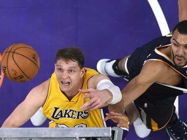 Ekspresi pemain Lakers, Timofey Mozgov, (kiri)  berebut bola rebound dengan pemain Utah Jazz, Rudy Gobert pada laga NBA basketball game di Los Angeles, (27/12/2016).  (AP/Mark J. Terrill)