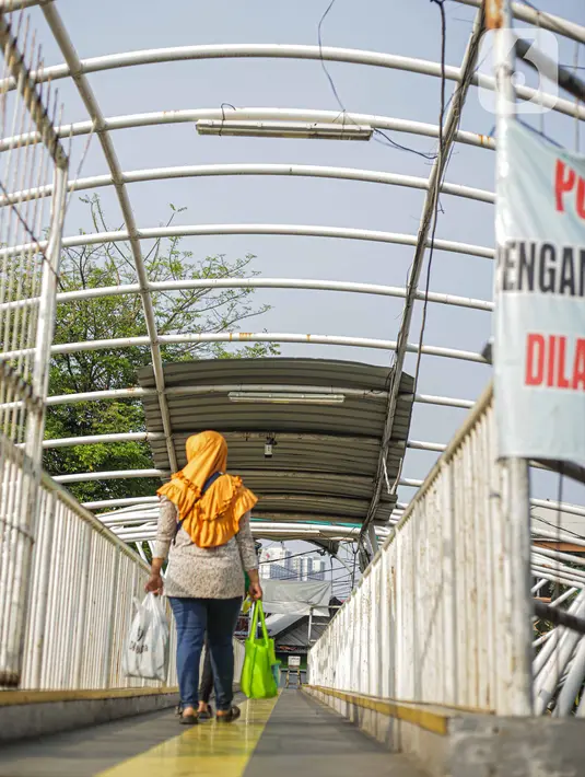 Warga melintasi jembatan penyeberangan orang (JPO) Jayakarta di kawasan Menteng, Jakarta, Kamis (12/11/2020). Kondisi JPO yang dibangun pada pertengahan 2016 tersebut kini sangat memprihatinkan dengan atap yang sebagian hilang. (Liputan6.com/Faizal Fanani)