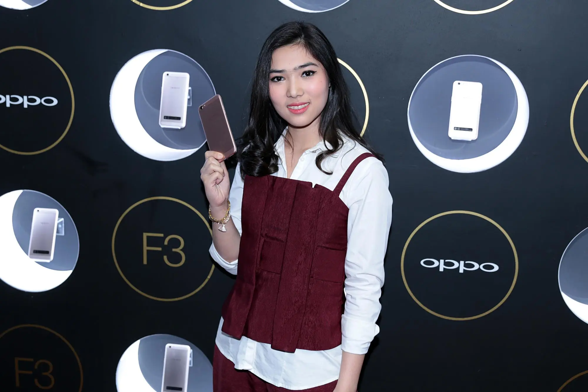 Isyana Sarasvati saat menunjukkan smartphone Oppo F3. (Deki Prayoga/Bintang.com)
