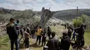 Penemuan ini merupakan dampak dari rentetan serangan rudal balistik yang diluncurkan Iran ke wilayah Israel dan sekitarnya. Tampak dalam foto, warga Palestina mengamati puing-puing rudal Iran yang jatuh di desa Kifl Haris, Tepi Barat, Selasa, 24 Maret 2026. (AP Photo/Majdi Mohammed)