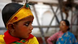 Seorang bocah berhias ala Dewa Krishna di perayaan Gaijatra Festival atau Festival Sapi di Kathmandu, Nepal, Jumat (19/8). Festival ini digelar untuk meminta keselamatan dan kedamaian. (REUTERS/ Navesh Chitrakar)