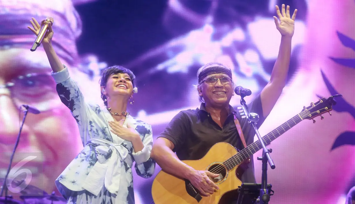 Musisi Iwan Fals berduet dengan penyanyi Andien pada konser Perayaan Karya Iwan Fals di Jakarta, Sabtu (03/9). Iwan Fals menggelar Konser yang bertepatan dengan HUT ke-55 sebagai bentuk apresiasi dari perjalanan karir. (Liputan6.com/Herman Zakharia)