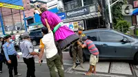 Petugas Suku Dinas Sosial dan Satpol PP Jakarta Selatan merazia pengamen ondel-ondel di kawasan Bulungan, Jakarta, Rabu (24/3/2021). Razia Penyandang Masalah Kesejahteraan Sosial (PMKS) dilakukan untuk ketertiban lingkungan dan terciptanya Ibu Kota yang bebas dari PMKS. (Liputan6.com/Faizal Fanani)