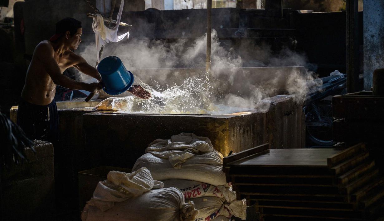 Namun, langkah tersebut dinilai hanya bisa menjadi solusi sementara apabila kenaikan harga terus berlangsung. Tampak dalam foto, seorang pekerja membuat tahu di sebuah pabrik, Surabaya, Jawa Timur pada Kamis 5 Februari 2026. (JUNI KRISWANTO/AFP)