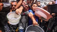 Warga Palestina berdesakan berebut makanan yang sudah dimasak dari dapur umum di Jabalia, Jalur Gaza Utara, pada 17 Mei 2025. (Bashar TALEB/AFP)