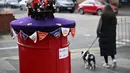 Pajangan rajutan warna merah, putih, biru dan ungu kerajaan bermunculan di kotak-kotak pos saat negara ini bersiap menyambut penobatan Raja Charles III. (Photo by Paul ELLIS / AFP)