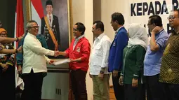 Ketua KPU Pusat Arief Budiman memberikan hasil penelitian administrasi Pemilu 2019 secara simbolis di KPU Pusat, Jakarta, Jumat (17/11). Sebanyak 14 parpol harus memperbaiki dokumen dalam berkas pendaftaran. (Liputan6.com/Angga Yuniar)