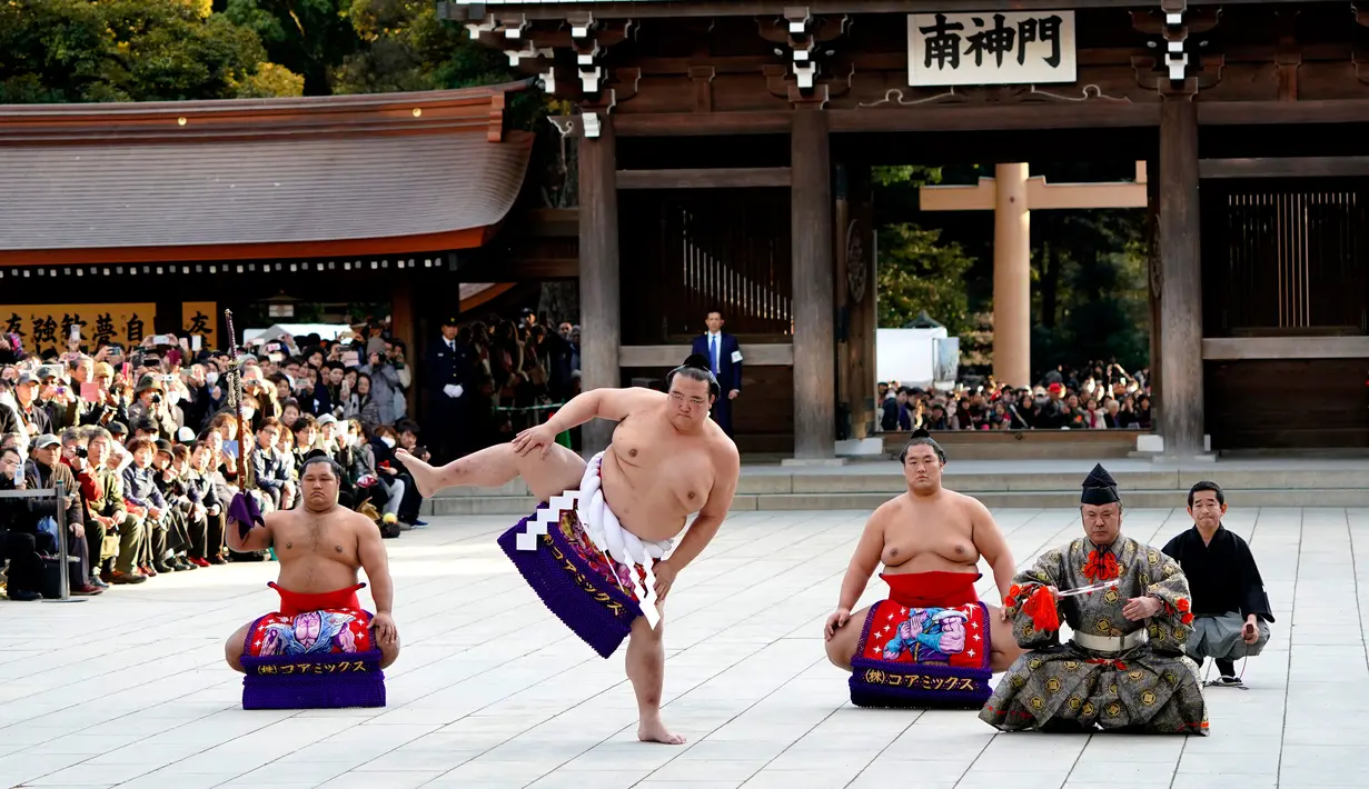 Juara Grand Sumo, Kisenosato melakukan upacara mengentakkan kaki di Kuil Shinto Meiji Shrine, Tokyo, Selasa (9/1). Ritual ini dilakukan dengan mengangkat secara bergantian kaki setinggi mungkin untuk kemudian dientakkan ke tanah. (AP/Shizuo Kambayashi)