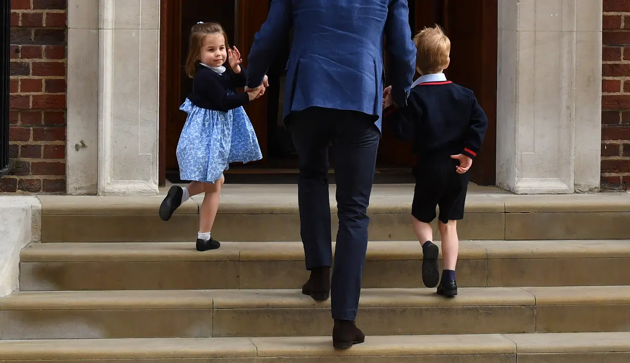 Pangeran George dan Putri Charlotte mengunjungi tempat Kate Middleton melahirkan di Rumah Sakit St Mary's, London, Senin (23/4). Berbeda dengan Pangeran George yang terlihat banyak menunduk, Putri Charlotte justru terlihat antusias. (Ben STANSALL/AFP)