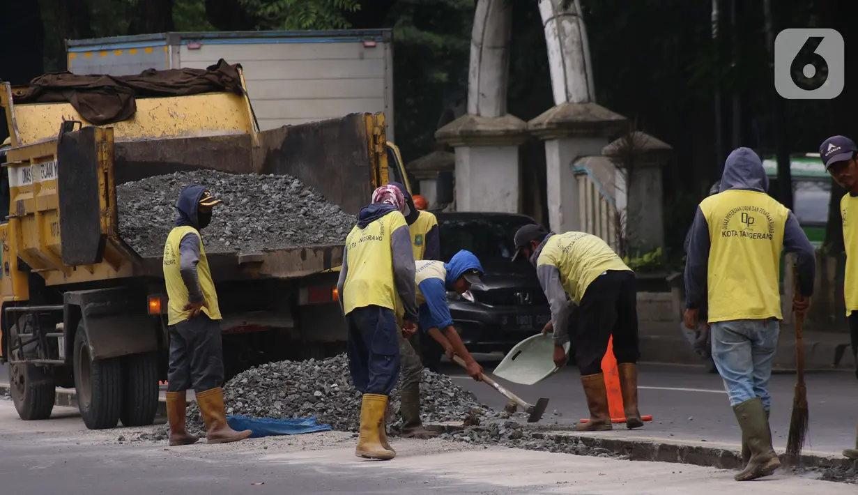 Pekerja melakukan penataan di ruas jalan nasional di Jalan Daan Mogot, Kota Tangerang, Banten, Selasa (15/2/2022). Pemkot Tangerang berencana melakukan sistem satu arah di Jalan Daan Mogot untuk mengatasi kemacetan di akses masuk tol Cengkareng-Batu Ceper-Kunciran. (Liputan6.com/Angga Yuniar)