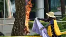 Wanita menolong Pria yang membakar dirinya sendiri depan Kantor Kedubes Jepang, Seoul, Korea Selatan, Rabu (12/8/2015). Aksi ini bentuk protes terhadap pemerintah Jepang yang selama Perang Dunia II memaksa wanita korea bekerja. (AFP PHOTO/JUNG YEON-JE)