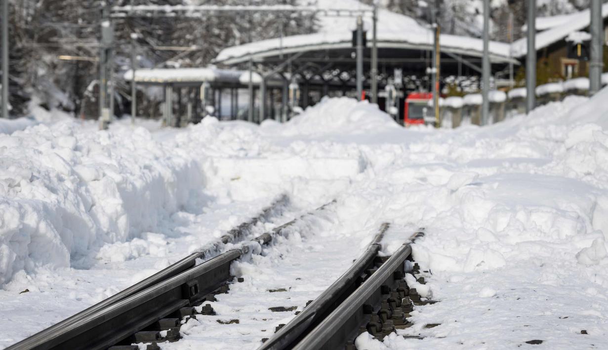 Kondisi rel kereta api yang tertutup salju tebal di desa Taesch, Pegunungan Alpen Swiss, (10/1). Pemadaman listrik di beberapa daerah lain, seperti di Kota Valais, juga terjadi akibat hujan salju lebat. (AFP Photo/Fabrice Coffrini)