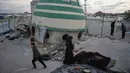Mereka larut dalam kebersamaan yang penuh haru dan sukacita meski berada di tengah reruntuhan akibat konflik yang berkepanjangan. Tampak dalam foto, Khadija Suleiman menyiapkan makanan untuk iftar keluarganya, yaitu hidangan berbuka puasa selama bulan suci Ramadhan, di reruntuhan masjid tempat mereka saat ini berlindung di Deir al-Balah, Jalur Gaza, Jumat 6 Maret 2026. (AP Photo/Abdel Kareem Hana)