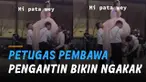Momen kocak terjadi saat salah seorang petugas pria bukannya mengangkat kaki pengantin wanita justru kaki temannya sendiri.