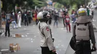 Polisi meminum air kemasan saat mengamankan aksi massa di kawasan Petamburan, Jakarta Barat, Rabu (22/5/2019). Hingga pukul 11.30 WIB, situasi berangsur kondusif. (Liputan6.com/Faizal Fanani)
