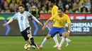 Penyerang Argentina, Lionel Messi (kiri) berusaha mengiring bola dari kawalan gelandang Brasil, Renato Augusto pada laga persahabatan di MCG di Melbourne (9/6). Argentina menang atas Brasil dengan skor 1-0. (AFP Photo/Mal Fairclough)