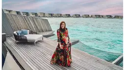 Liburan ke Maldives, Maia Estianty menunjukkan raut wajah yang sangat bahagia. Menetap di sebuah penginapan tepi pantai Maldives yang terkenal, Maia tampak anggun menggunakan dress panjang hitam bermotif. (Liputan6.com/IG/@maiaestiantyreal)