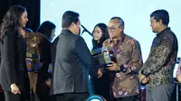Menteri BUMN Erick Thohir menyerahkan  penghargaan bergengsi dalam ajang BUMN Corporate Communications and Sustainability Summit (BCOMSS) 2024 kepada Direktur Human Capital and Compliance BNI Mucharom di Tennis Indoor Senayan, Jakarta, Kamis (7/3/2024).
