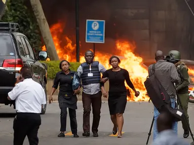 Pasukan keamanan membantu warga melarikan diri dari lokasi penyerangan sebuah kompleks hotel mewah di Nairobi, Kenya, Selasa (15/1). Dilansir dari CNN, 15 orang dinyatakan tewas dalam serangan tersebut. (AP Photo/Ben Curtis)
