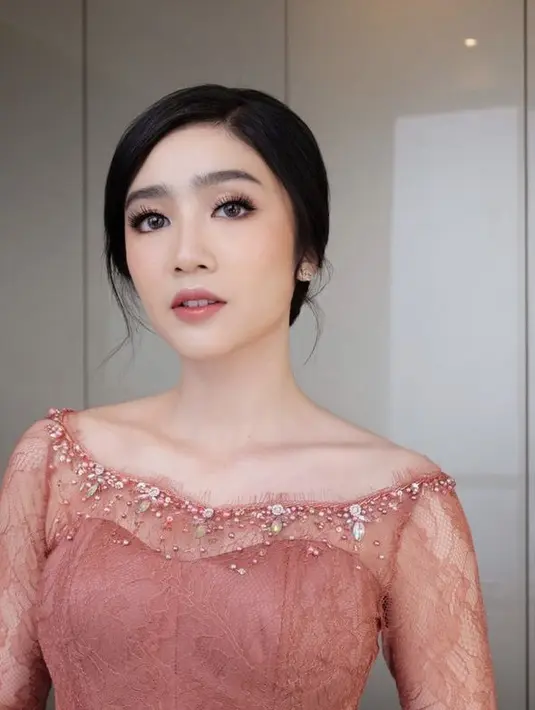 Febby Rastanty tampil flawless namun terlihat fresh. MUA Yoshi memulas blus on coral di pipinya serta lipstik pink glossy. Credit: (@febbyrastanty)