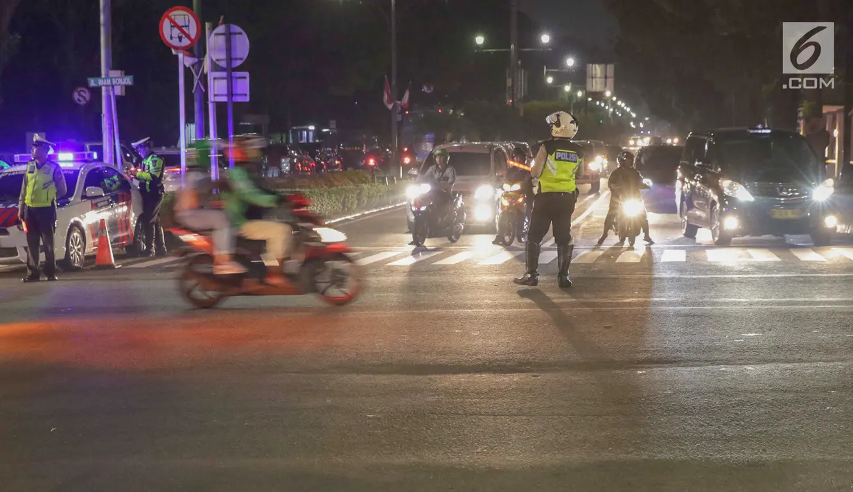 Petugas Kepolisian mengatur pengalihan arus lalu lintas di sekitar perempatan jalan Imam Bonjol dekat Gedung KPU RI, Jakarta, Senin (20/5/2019). Jelang penetapan Presiden dan Wakil Presiden terpilih pada Pemilu 2019, jalan Imam Bonjol di sterilkan hingga 25 Mei. (Liputan6.com/Helmi Fithriansyah)