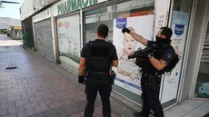 Petugas polisi Prancis berpatroli di lingkungan populer Pissevin di Nimes, Prancis selatan pada 22 Agustus 2023, setelah seorang anak tewas dalam baku tembak. (AFP/Nicolas Tucat)