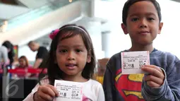 Dua anak memperlihatkan tiket nonton Peanut Snoopy di Blitz Megaplex, Jakarta, Sabtu (12/12/2015). Nonton bareng tersebut diselenggarakan oleh Cinemaholic Liputan6.com bekerjasama dengan Lipton. (Liputan6.com/Angga Yuniar)