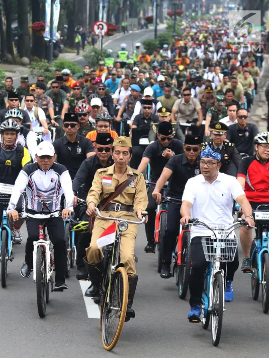 Presiden Joko Widodo (tengah) didampingi Gubernur Jawa Barat Ridwan Kamil (kanan) saat mengikuti Bandung Lautan Sepeda, Sabtu (10/11). Kegiatan yang diadakan oleh Kodam III/Siliwangi ini dalam rangka memperingati Hari Pahlawan. (Liputan6.com/Angga Yuniar)