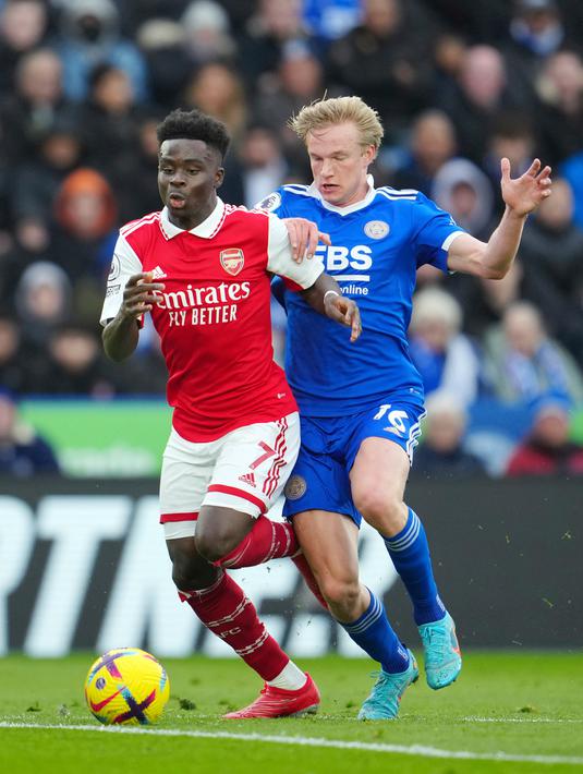 Pemain Arsenal Bukayo Saka (kiri) memperebutkan bola dengan pemain Leicester City Victor Kristiansen pada pertandingan sepak bola Liga Inggris di The King Power Stadium, Leicester, Inggris, 25 Februari 2023. Arsenal mengalahkan Leicester City dengan skor 1-0. (AP Photo/Jon Super)