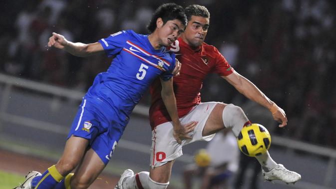 Penyerang Timnas Indonesia, Cristian Gonzales, berduel dengan Suttinun Phukhom pada laga Piala AFF 2010.(AFP/Romeo Gacad)