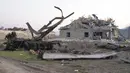 Sebuah bangunan dan kendaraan hancur setelah penembakan oleh artileri Azerbaijan selama konflik militer dengan Armenia di luar Stepanakert, wilayah separatis Nagorno-Karabakh, Senin (19/10/2020). Pertempuran di Nagorno-Karabakh berkecamuk selama lebih dari tiga minggu. (AP Photo)