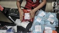 Petugas mengemas barang costumer yang akan dikirim melalui jasa ekspedisi JNE di Tomang, Jakarta, Selasa (29/12/2020). Penggunaan jasa ekspedisi atau kurir meningkat hingga 85 persen selama pandemi COVID-19. (merdeka.com/Iqbal S. Nugroho)