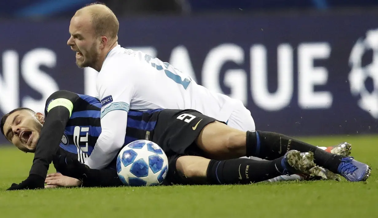 Striker Inter Milan, Mauro Icardi, terjatuh saat berebut bola dengan pemain PSV Eindhoven, Jorrit Hendrix, pada laga Liga Champions di Stadion San Siro, Italia, Selasa (11/12). Kedua tim bermain imbang 1-1. (AP/Luca Bruno)