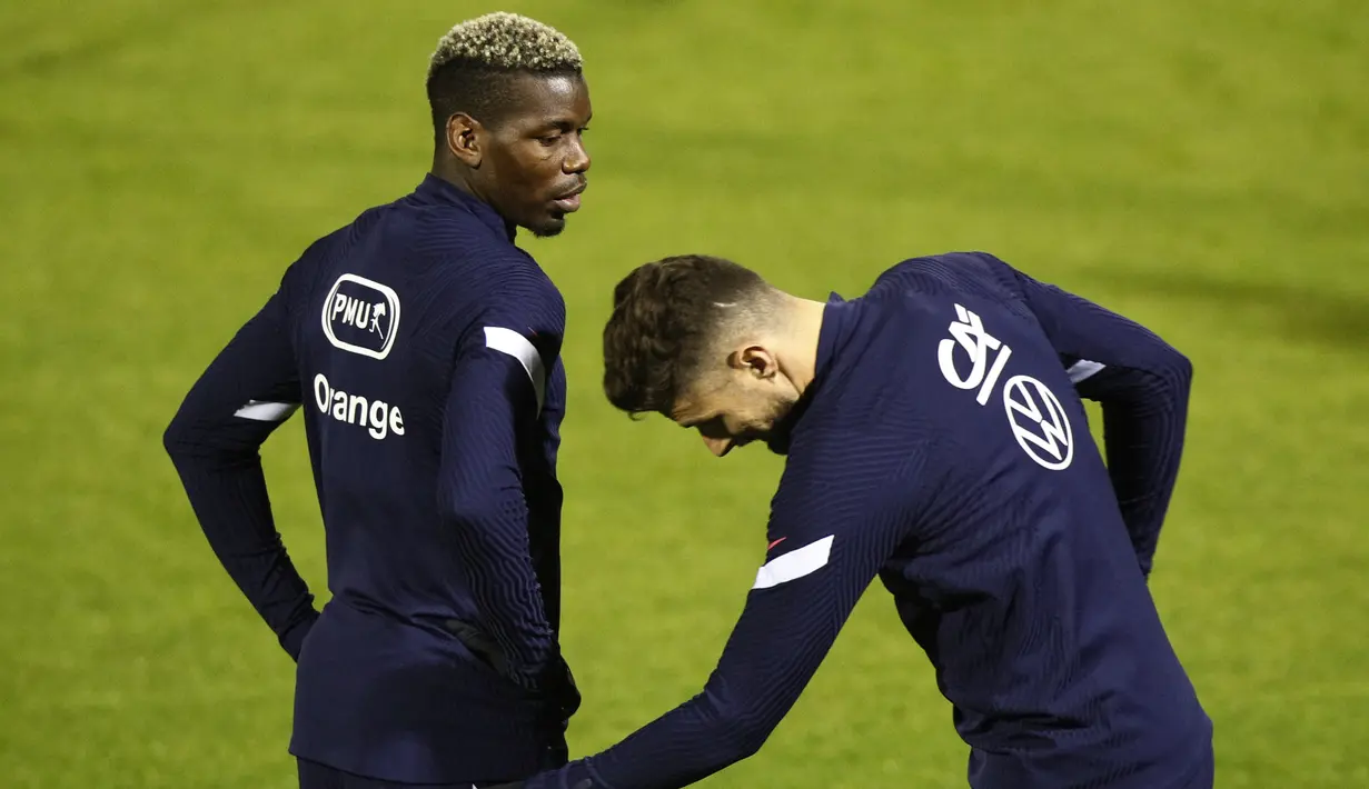 Gelandang Prancis Paul Pogba dan penyerang Olivier Giroud berbicara selama sesi latihan di Clairefontaine-en-Yvelines, Paris, Selasa (10/11/2020). Prancis akan melawan Finlandia di Stade de France pada Kamis (12/11) dini hari WIB dalam pertandingan persahabatan internasional. (Yoan VALAT/POOL/AFP)