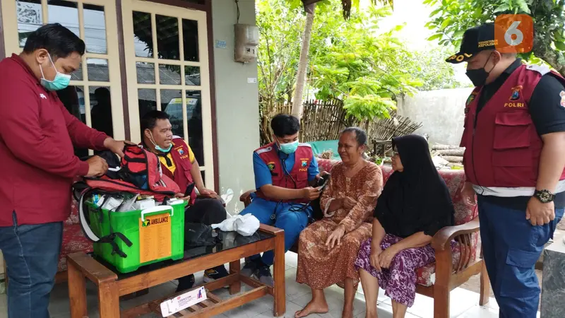 Petugas Kesehatan dari Polresta Banyuwangi memeriksa warga korban banjir Banyuwangi (Hermawan Arifianto/Liputan6.com)