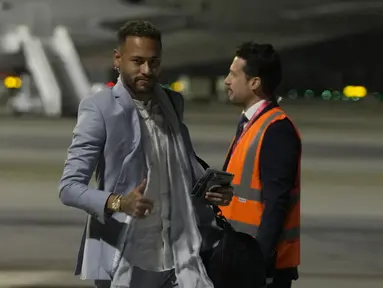 Penyerang Brasil Neymar memberi isyarat saat tiba dengan rekan setimnya menjelang Piala Dunia mendatang di bandara Internasional Hamad di Doha, Qatar, Sabtu (19/11/2022). Penerbangan Amerika Selatan dari Turin di Italia tempat timnas Brasil bermarkas minggu ini mendarat sekitar pukul 23:00 waktu setempat (21:00GMT). (AP Photo/Hassan Ammar)