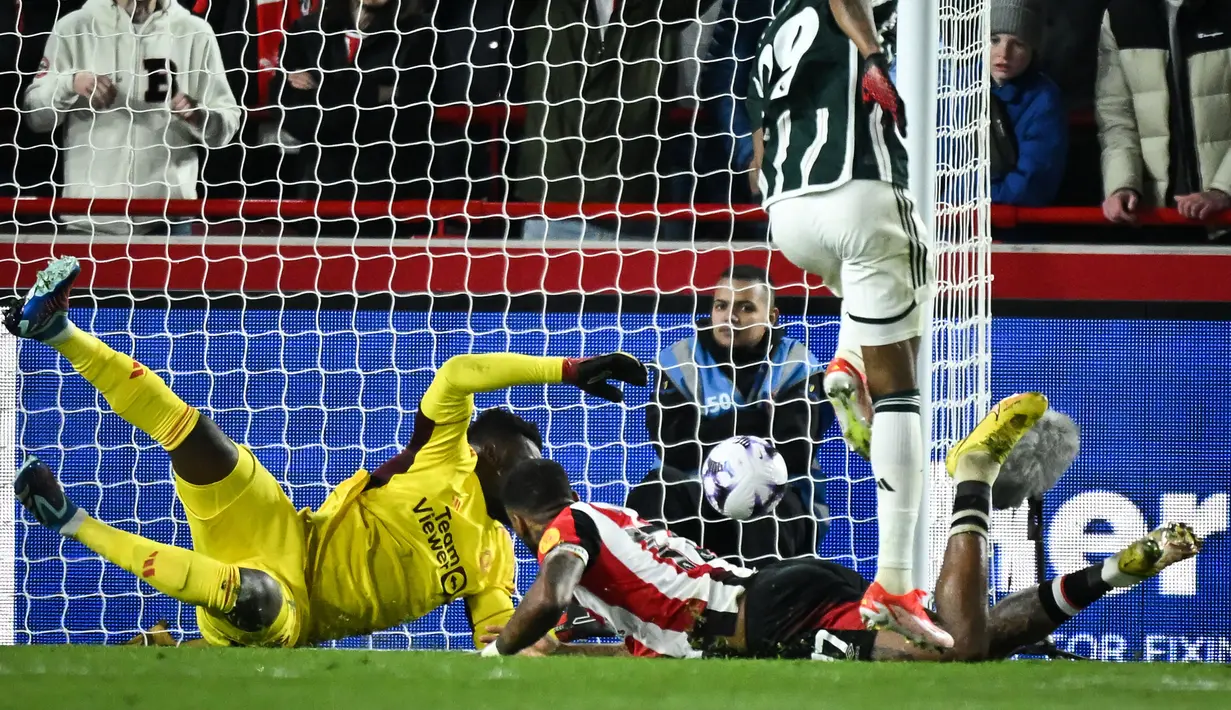 Striker Brentford, Ivan Toney (kanan bawah) mencetak gol ke gawang Manchester United yang akhirnya dianulir VAR karena terlebih dahulu terperangkap offside pada laga pekan ke-30 Premier League 2023/2024 di Gtech Community Stadium, London, Sabtu (30/3/2024). (AFP/Justin Tallis)