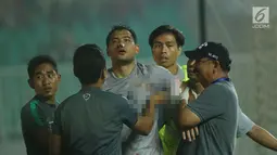 Penjaga gawang Indonesia U-23, Andritany (tengah) dibopong keluar lapangan saat laga melawan Uzbekistan pada PSSI Anniversary 2018 di Stadion Pakansari, Kab Bogor, Kamis (3/5). Babak pertama imbang 0-0. (Liputan6.com/Helmi Fithriansyah)