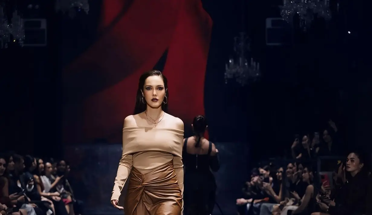 Perempuan 42 tahun itu tampil memikat dengan sabrina top dan leather wrapped skirt berwarna cokelat [@cathysharon]