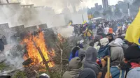 Demonstran membakar pohon di luar gedung parlemen di Quito (8/10/2019). Unjuk rasa ini telah berlangsung selama beberapa hari dan diikuti berbagai elemen termasuk masyarakat adat. (AFP Photo/Martin Bernetti)