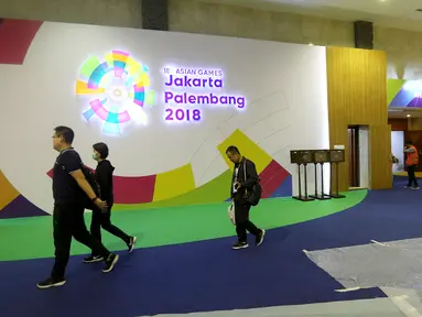 Panitia Inasgoc melintas di loby Main Press Center (MPC) atau media center bagi jurnalis untuk pelaksanaan Asian Games 2018 terus dibangun di Exhibition Hall JCC, Jakarta, Kamis (9/8). MPC akan beroperasi pada 10 Agustus. (Liputan6.com/Fery Pradolo)